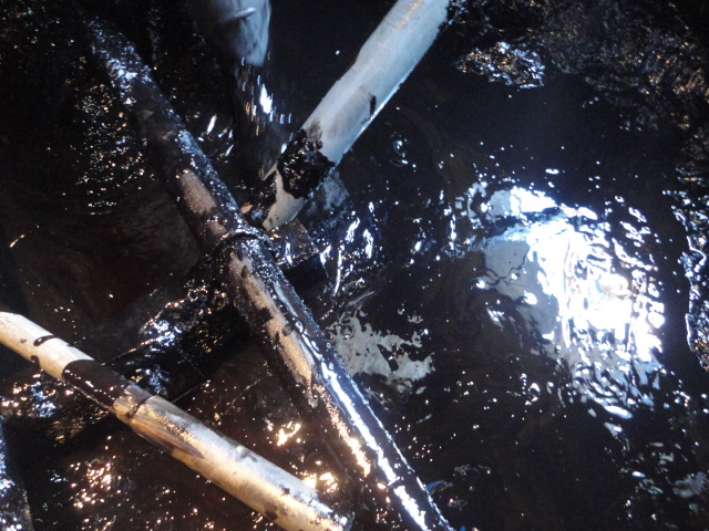 タンクローリーで内部に残った廃油とスラッジを吸引する作業の写真